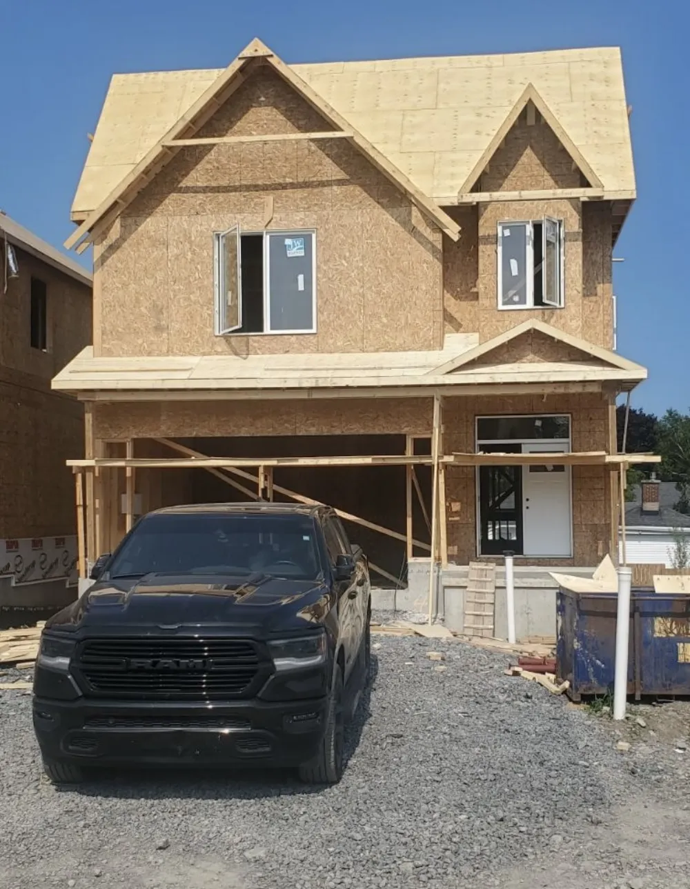 Framed detached home with garage opening and covered porch