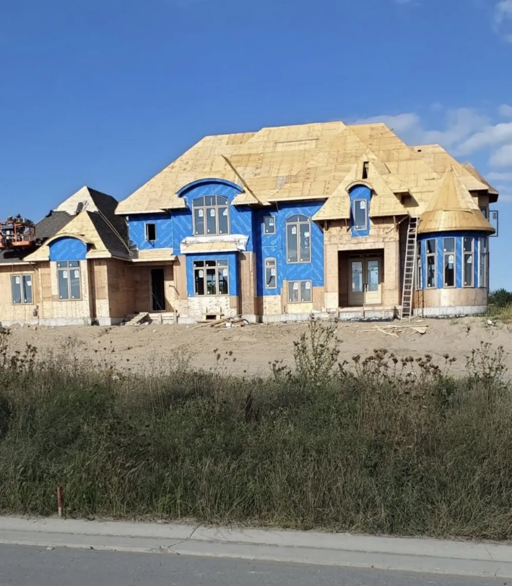 Large custom home framed with roof sheathing and turret