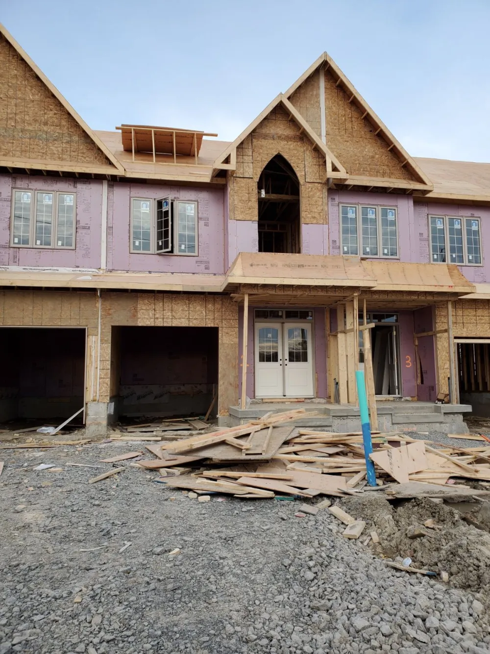 Semi-detached homes framed with gable roofs and front porches